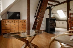 Wohnzimmer mit Kaminofen und Aufgang zum Dachspitz -  Foto: A. Declair